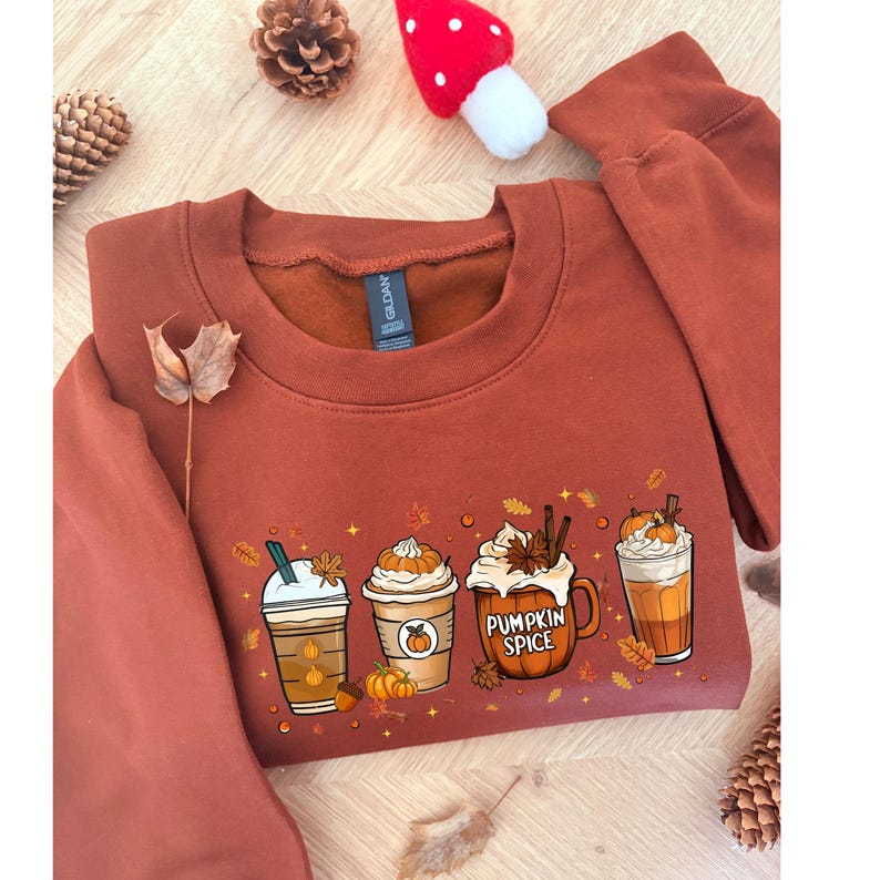 Zacht en comfortabel herfst sweatshirt met cozy design van koffie en pompoen. Perfect voor herfstliefhebbers, pumpkin spice fans en iedereen die houdt van knusse herfstoutfits. Ideaal als Halloween trui, casual herfstkleding of cadeau voor boekenliefhebbers en koffie drinkers tijdens het spooky season.