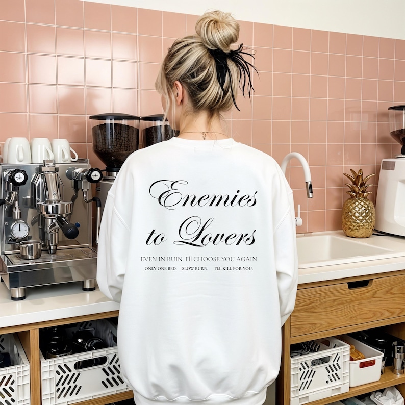 Minimalistisch “Enemies to Lovers” tekstdesign op hoodie, sweatshirt of T-shirt voor romance readers. Perfect voor fans van de enemies-to-lovers trope en bookish fashion. Zacht, comfortabel en ideaal om te dragen tijdens het lezen. Stijlvol cadeau voor boekenliefhebbers.