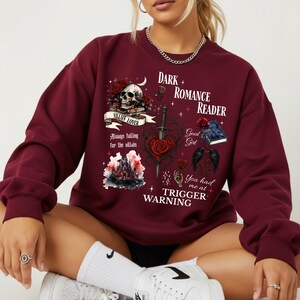 Minimalistisch “Dark Romance Reader” tekstdesign op hoodie, sweatshirt of T-shirt voor romance readers. Perfect voor fans van de enemies-to-lovers trope en bookish fashion. Zacht, comfortabel en ideaal om te dragen tijdens het lezen. Stijlvol cadeau voor boekenliefhebbers.