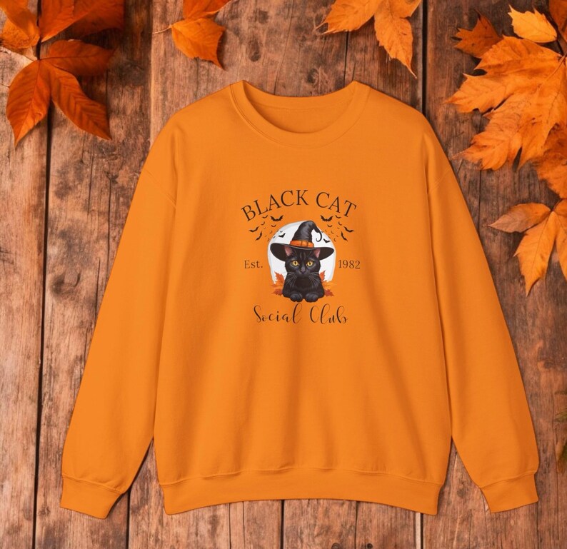 Schattige zwarte kat met een heksenhoed, perfect in Halloween-stijl, gedrukt op een comfortabel sweatshirt en t-shirt.