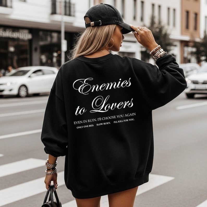 Minimalistisch “Enemies to Lovers” tekstdesign op hoodie, sweatshirt of T-shirt voor romance readers. Perfect voor fans van de enemies-to-lovers trope en bookish fashion. Zacht, comfortabel en ideaal om te dragen tijdens het lezen. Stijlvol cadeau voor boekenliefhebbers.