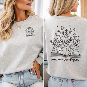 Een must-have voor elke boekenliefhebber! Deze comfy sweatshirt heeft een opvallend design met de tekst Just One More Chapter, een open boek en sierlijke bloemen. Dubbelzijdig bedrukt en verkrijgbaar in verschillende kleuren, maten én als T-shirt of hoodie. Perfect om in weg te kruipen met je favoriete verhaal – of dat ene hoofdstuk dat je móet uitlezen. Ideaal als cadeau of om je eigen leesverslaving te vieren! 📚✨