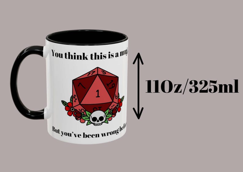 May include: White ceramic mug with a black handle and rim, featuring a red D20 die design with a skull and floral accents. The mug has the text "You think this is a mug... But you've been wrong before." It holds 110 oz (325ml).