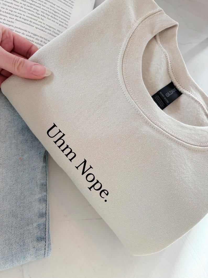Geborduurd sweatshirt met de tekst “Uhm Nope.” in een minimalistisch lettertype. De trui heeft een comfortabele pasvorm en een rustige, stijlvolle uitstraling. Het ontwerp straalt humor, zelfbeschikking en duidelijke grenzen uit. Geschikt voor casual outfits, relaxmomenten of als origineel cadeau voor iemand die vandaag gewoon even nee zegt.