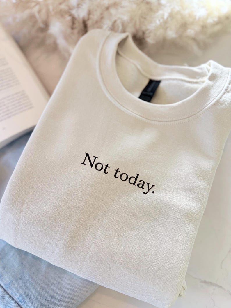 Grappige statement T-shirt met de tekst “Not today” in een minimalistisch en modern lettertype. Het ontwerp straalt humor, zelfverzekerdheid en duidelijke grenzen uit. Geschikt als casual outfit of comfy sweatshirtlook. Perfect als cadeau voor je vriendin of voor jezelf, voor iedereen die met een knipoog nee durft te zeggen. Tijdloos, stijlvol en makkelijk te combineren.