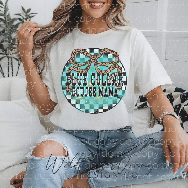 May include: White t-shirt with a round graphic that reads "BLUE COLLAR BOUJEE MAMA." The graphic features a turquoise and black checkered background, a leopard print bow, and text in black and turquoise. The shirt is short-sleeved.