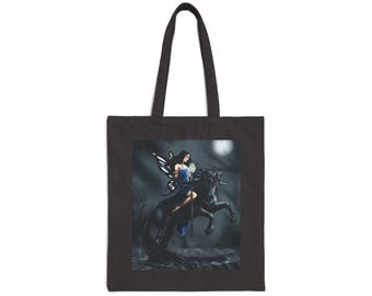 Puede incluir: Bolso tote negro con una ilustración de fantasía. La obra de arte representa a una mujer con alas de hada montada en un unicornio negro en un bosque iluminado por la luna. La mujer lleva un vestido azul y sostiene un reloj.