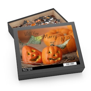 May include: A black puzzle box with a Halloween-themed image. The image features carved pumpkins with the text "Will You Marry Me?" The box contains 120 pieces and is 8x10 inches.