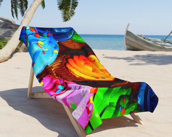 Puede incluir: Una colorida toalla de playa con un diseño abstracto de vibrantes azules, verdes, rosas y naranjas, colocada sobre una silla de playa de madera. El patrón de la toalla se asemeja a un primer plano de una pintura colorida. La escena está ambientada en una playa de arena con un barco al fondo.