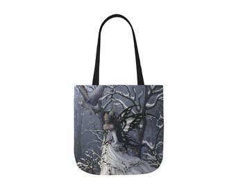 Puede incluir: Un bolso tote negro con un estampado de arte fantástico. La obra de arte representa a una mujer con un vestido blanco con alas negras, un búho y un fondo de bosque nevado. El bolso tiene asas negras.