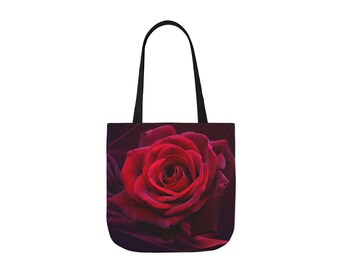 Op de afbeelding: Tote bag met een grote, levendige rode roos. De roos staat centraal, tegen een donkere achtergrond. De tas heeft zwarte handvatten en is een stijlvol en praktisch accessoire voor dagelijks gebruik.