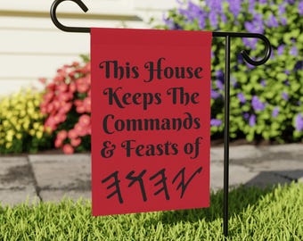 Op de afbeelding: Rode tuin vlag met zwarte tekst die "This House Keeps The Commands & Feasts of Freya" luidt.
