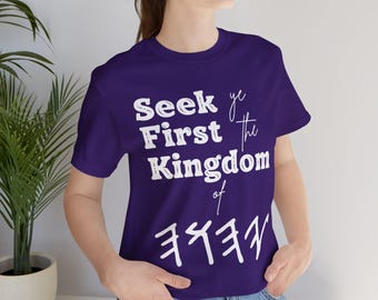 May include: Purple t-shirt with white text that reads "Seek ye First the Kingdom of  " followed by a symbol.