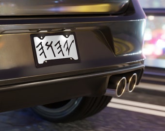 Op de afbeelding: Een zwarte auto met een kentekenplaat waarop "F33F" in witte letters staat. De auto heeft twee uitlaatpijpen aan de achterkant.