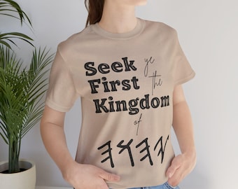 May include: A beige t-shirt with the text "Seek ye First the Kingdom of" and a symbol below the text.