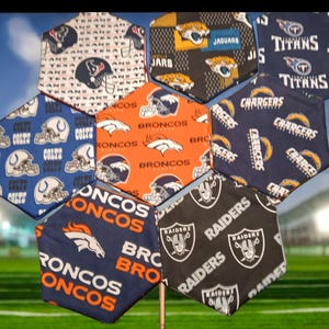 May include: A collection of hexagon-shaped fabric patches featuring various NFL team logos and colors. Teams include the Texans, Jaguars, Titans, Chargers, Broncos, Colts, and Raiders. The patches are arranged in a honeycomb pattern.