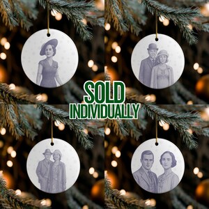 May include: White ceramic Christmas ornaments with vintage-style portraits of people, hanging from a Christmas tree. The ornaments have gold string hangers. The text "SOLD INDIVIDUALLY" is in green and white. Each ornament features a different portrait.