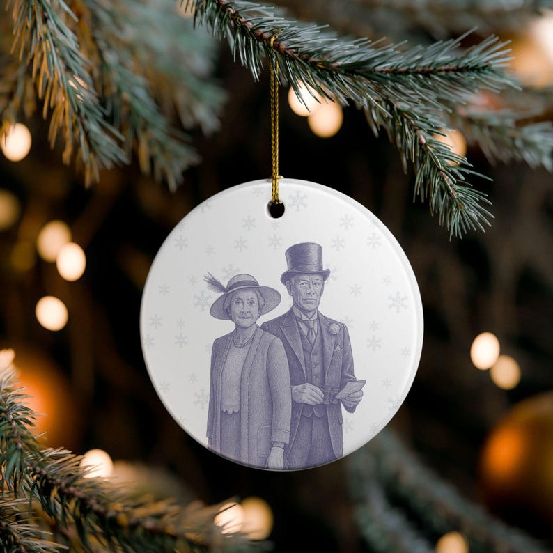 May include: A round Christmas ornament with a vintage illustration of a well-dressed couple in shades of purple. The woman wears a hat with a feather, and the man wears a top hat. The background has a snowflake pattern.