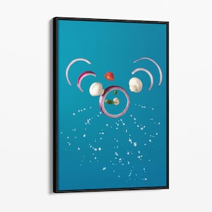 May include: A blue background with a red onion, white mushrooms, a red tomato, and green herbs arranged to form a face. Salt is scattered around the face.