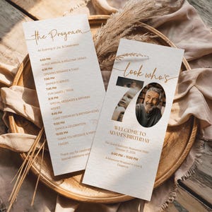 May include: Two beige event programmes with gold text, one titled "The Program" and the other "look who's 70". The programmes include event details, photos, and the text "Welcome to Adam's Birthday".