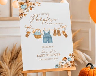 Puede incluir: Un letrero de bienvenida blanco sobre un caballete de madera, decorado con ilustraciones de acuarela de calabazas, petos y zapatos de bebé. El letrero dice "A Little Pumpkin is on the Way" y da la bienvenida a los invitados al Baby Shower de Amanda el 25 de octubre de 2025.