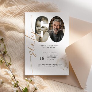May include: A white invitation card with gold lettering announcing a 60th birthday party. The invitation features a photo of a man and a young boy, both smiling. The text reads "Steve is turning sixty soon" and includes the date, time, and location of the party.