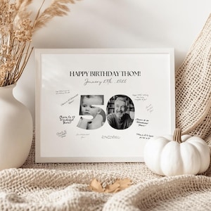 May include: A framed black and white photo print with the text "HAPPY BIRTHDAY THOM!" and "January 27th, 2026". The number "50" is formed by two photos, with handwritten messages around the images.