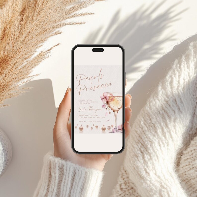 May include: A digital invitation for a bridal shower with the text "Pearls & Prosecco" in rose gold lettering. The invitation features a watercolor illustration of a champagne flute with pink flowers and gold pearls.