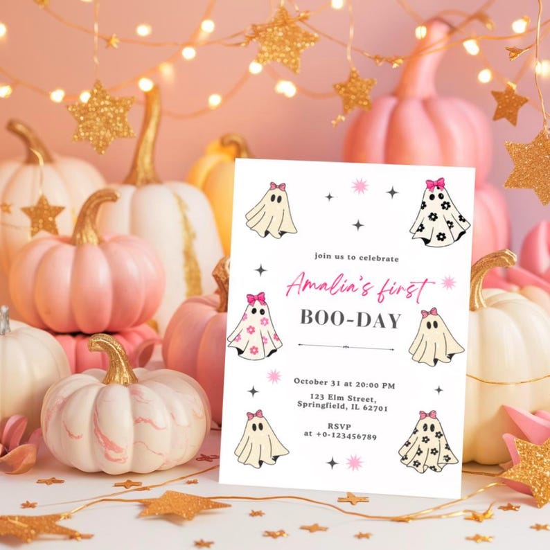 May include: A Halloween-themed invitation with ghost illustrations and the text "Amalia's first BOO-DAY." The invitation is surrounded by pink and white pumpkins with gold stems, and gold star decorations.