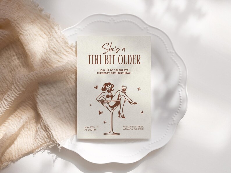 May include: A brown invitation card with the text "She's a Tini Bit Older" and a graphic of a woman in a martini glass. The text below the graphic says "Join us to celebrate Theresa's 30th Birthday!" and includes the date, time, and address of the event.