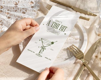May include: A white menu with green text and a drawing of a martini glass. The menu says "Emma's A Tini Bit Older" and "Est. 2025 April 11th".