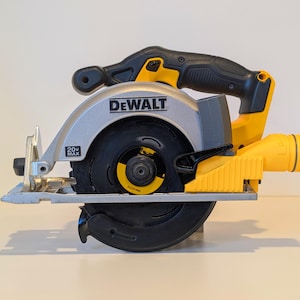 以下が含まれることがあります： シルバーの刃ガード、黒と黄色のハンドル、黒い刃を備えたDeWalt 20V MAX丸鋸。鋸は黄色と黒のボディで、DeWaltのロゴがはっきりと表示されています。