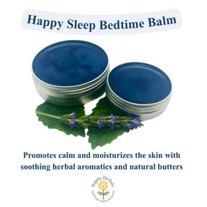 May include: Two round silver metal tins containing a deep blue balm, positioned above green leaves with small purple flowers. Text reads: Happy Sleep Bedtime Balm. Promotes calm and moisturizes the skin with soothing herbal aromatics and natural butters. Ripple Herbals logo at the bottom.