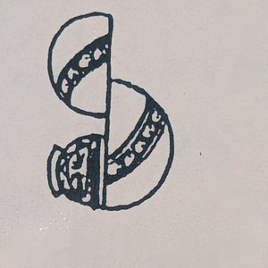 May include: A black and white illustration of a stylized letter S with a decorative design.