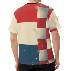 May include: A short-sleeved t-shirt with a geometric design. The shirt features a color block pattern with red, white, and blue sections. The design has a distressed, vintage look. The shirt has a black collar.