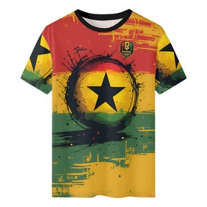May include: A short-sleeved t-shirt featuring the Ghana flag design. The shirt has a black crew neck and a design that includes a large black star inside a black circle, with the colors red, yellow, and green. The Ghana emblem is on the upper right.