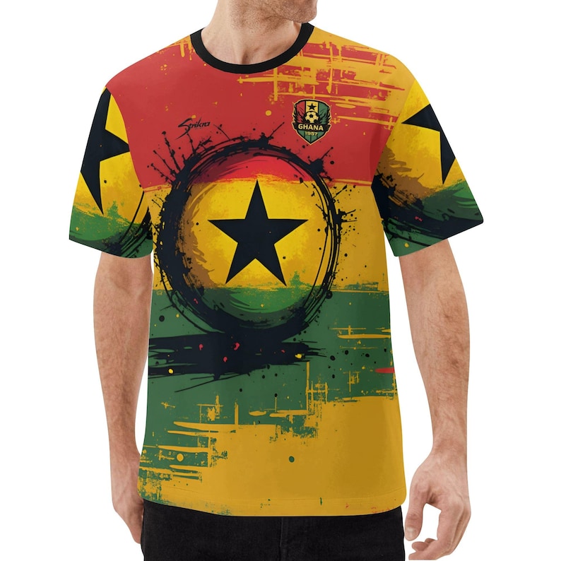 May include: A short-sleeved t-shirt featuring the Ghana flag design. The shirt has a black crew neck and a vibrant print with the colors red, yellow, and green. A black star is in the center, surrounded by a black circle and splatter design. The word "Ghana" is printed on the shirt.