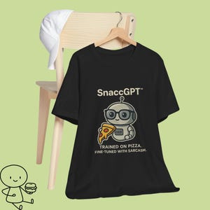 Könnte beinhalten: Schwarzes T-Shirt mit einem Cartoon-Roboter, der eine Brille trägt und ein Pizzastück hält. Der Text "SnaccGPT" steht über dem Roboter, darunter "TRAINED ON PIZZA. FINE-TUNED WITH SARCASM.". Eine weiße Baseballkappe liegt auf einem Holzstuhl.