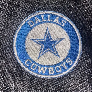 May include: An embroidered patch featuring the words "Dallas Cowboys" and a five-pointed star, in blue and white.