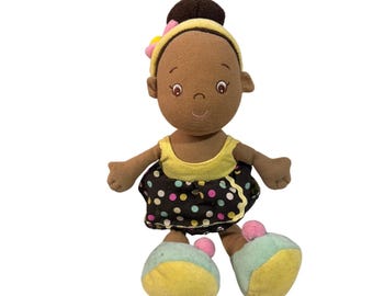 Muñeca de peluche Aurora Baby para niña, falda marrón de lunares y diadema amarilla. Juguete suave.