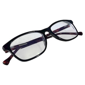 Op de afbeelding: Zwarte rechthoekige bril met heldere glazen. De monturen zijn dik en glanzend, met een donker schildpadpatroon zichtbaar op de binnenarmen en slapen. De bril is ontworpen voor gezichtscorrectie.