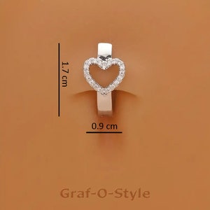 May include: Silver heart-shaped hoop earring with clear cubic zirconia stones. The earring measures 1.7 cm in height and 0.9 cm in width.