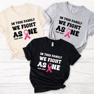In questa famiglia combattiamo come una camicia per la consapevolezza del cancro, camicia di supporto per il gruppo familiare del cancro, camicia di supporto per il cancro personalizzata personalizzata