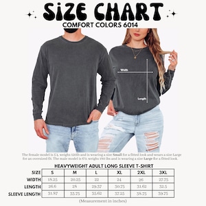 以下が含まれることがあります： Comfort Colors 6014 チャコールグレーの長袖Tシャツサイズチャート。画像には、Sから3XLまでのサイズに対応する幅、着丈、袖丈のインチ単位の測定値を示す表と、Tシャツを着用した2人の人物が写っています。