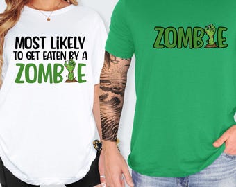 May include: Two t-shirts, one white and one green. The white shirt has the text "MOST LIKELY TO GET EATEN BY A ZOMBIE" in black and green. The green shirt has the word "ZOMBIE" in green with a zombie hand graphic.