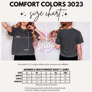 以下が含まれることがあります： チャコールグレーのボックス型Tシャツを前後から見た画像。Comfort Colors 3023のサイズチャートが含まれており、Sから2XLまでの幅、胸囲、着丈がインチ単位で記載され、生地の仕様についても説明されています。