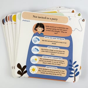 Può includere: Un mazzo di carte illustrate con il titolo "Non invitato a una festa". Le carte presentano una ragazza dei cartoni animati e testo sulla gestione delle emozioni, tra cui "Nota e nomina il sentimento" e "Azione positiva".
