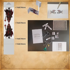 Puede incluir: Un kit de manualidades en papel con ilustraciones de un personaje con capucha en t&uacute;nicas rojas y negras que sostiene un bast&oacute;n. El kit incluye varias secciones para recortar, l&iacute;neas de plegado marcadas como "Fold Here", tijeras y una base cuadriculada.