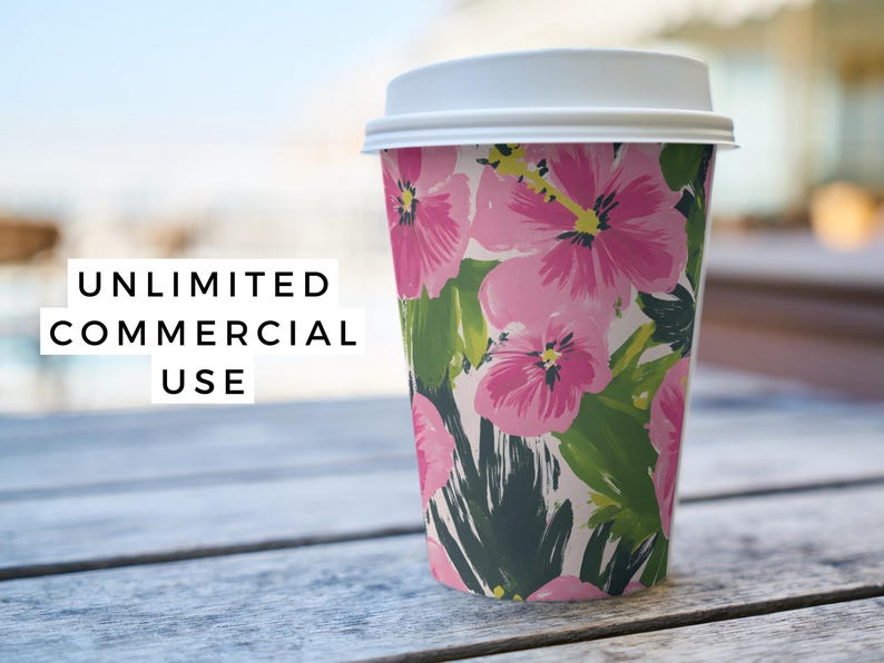 Puede incluir: Un vaso de papel blanco con un dise&ntilde;o floral con flores de hibisco rosas y hojas verdes. El vaso tiene una tapa blanca.