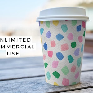 May include: A white paper coffee cup with a white lid, decorated with colorful abstract shapes in blue, green, pink, purple, and yellow. The text "UNLIMITED COMMERCIAL USE" is displayed in a white box.